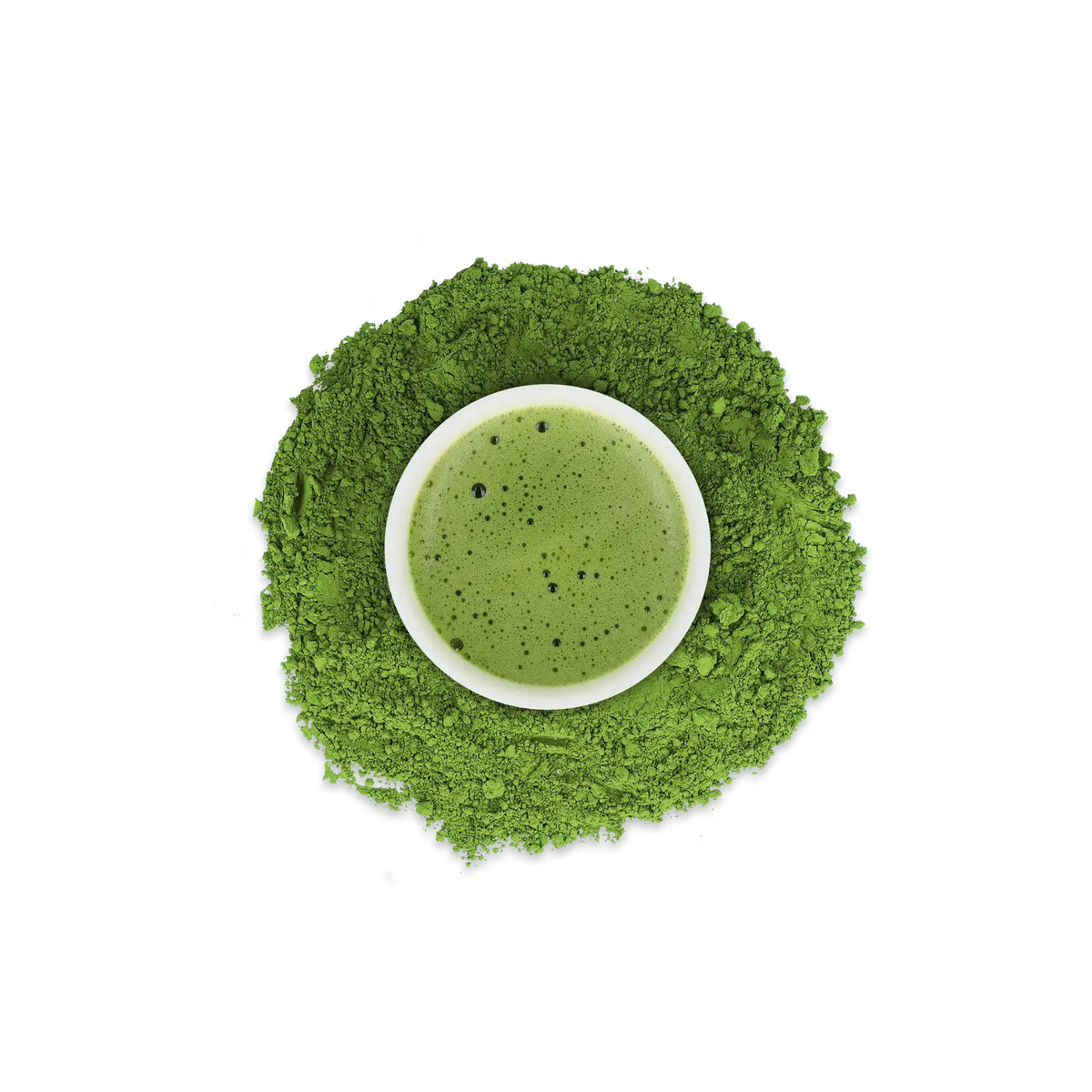 Kleine weiße Schale mit schaumigem grünen Matcha-Tee, umgeben von lebhaftem Matcha-Pulver auf weißem Hintergrund.