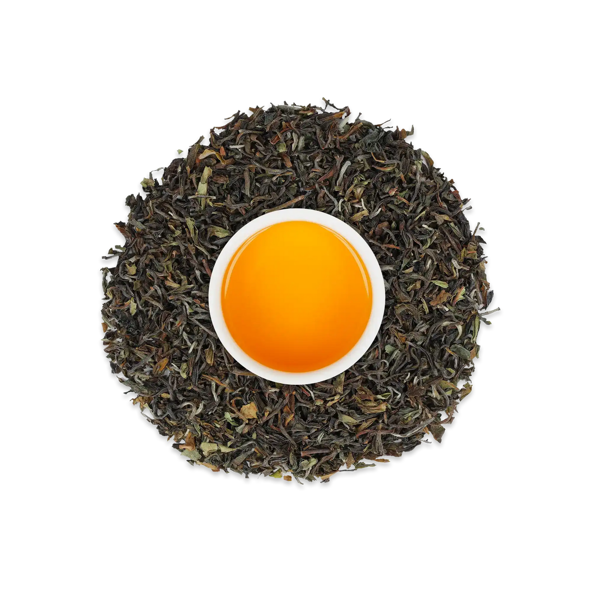 Weiße Keramiktasse mit orangem Tee, umgeben von schwarzen Teeblättern auf weißem Hintergrund.