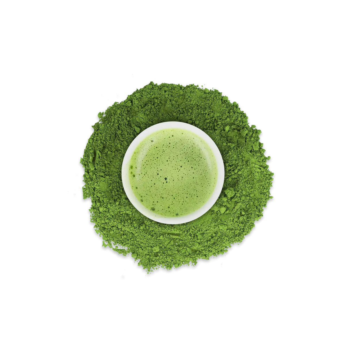 Weiße Schale mit schaumigem Matcha-Tee in einem Kreis aus lebhaft grünem Matcha-Pulver auf weißem Hintergrund.
