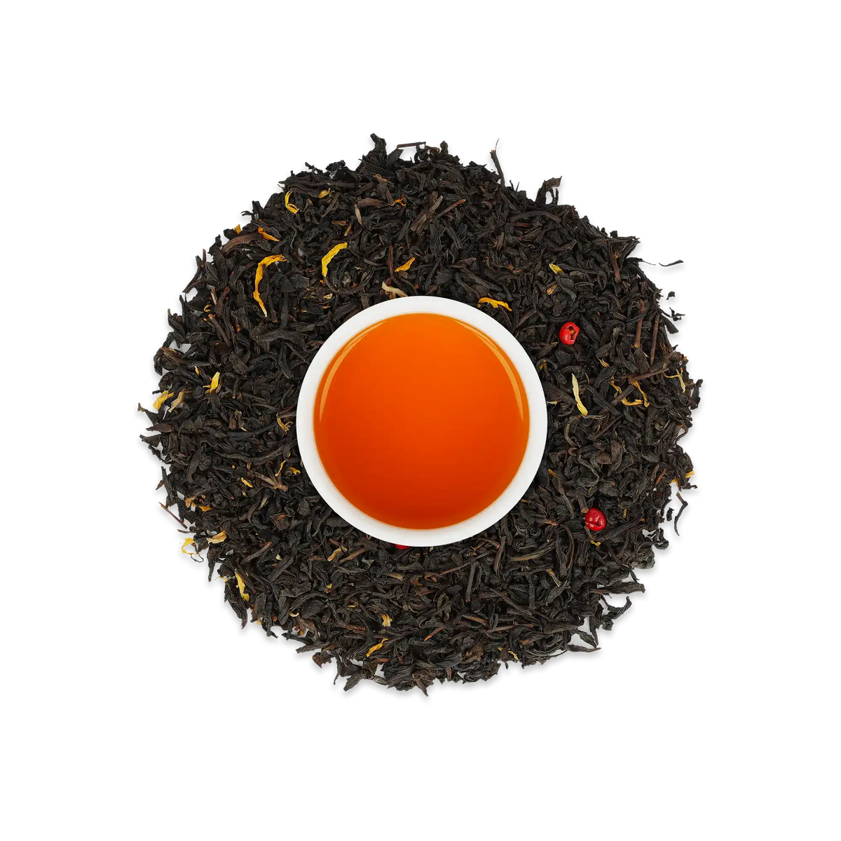 Weiße Tasse mit orangebraunem Tee, umgeben von losem schwarzen Tee mit gelben und roten Blättern.