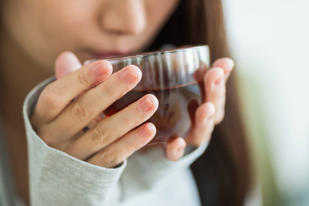 Frau genießt Tee aus Tasse