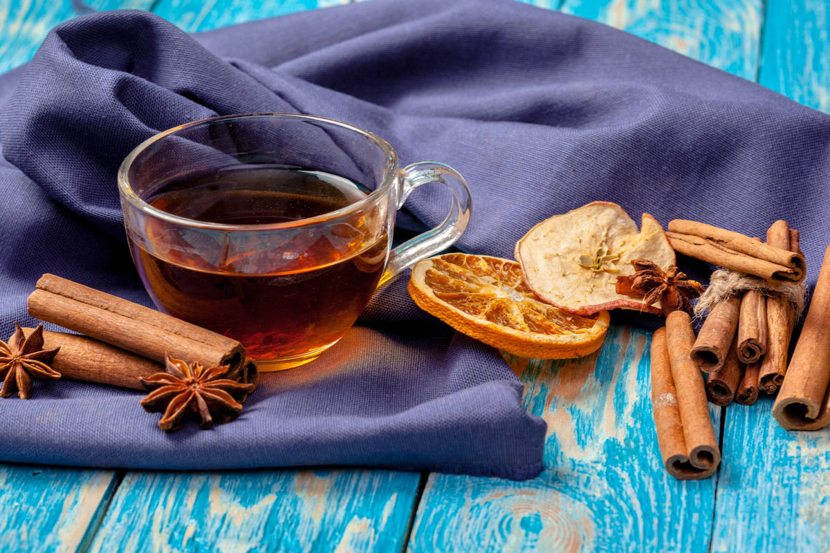 Tasse Gewürztee mit Zimtstangen, Anis und Orangenscheibe