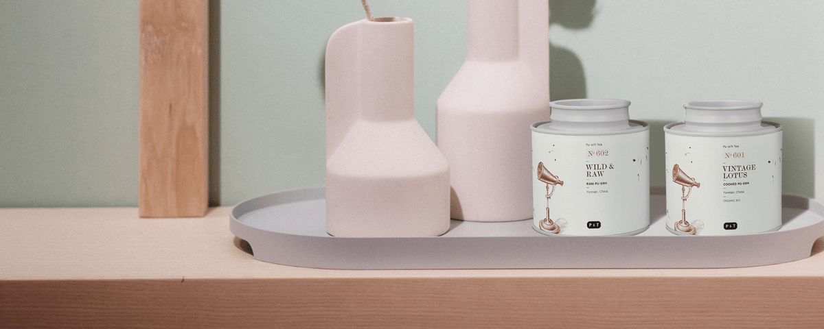 Pu Erh Tee von P&T auf einem schönen Holzregal mit Blumenvasen
