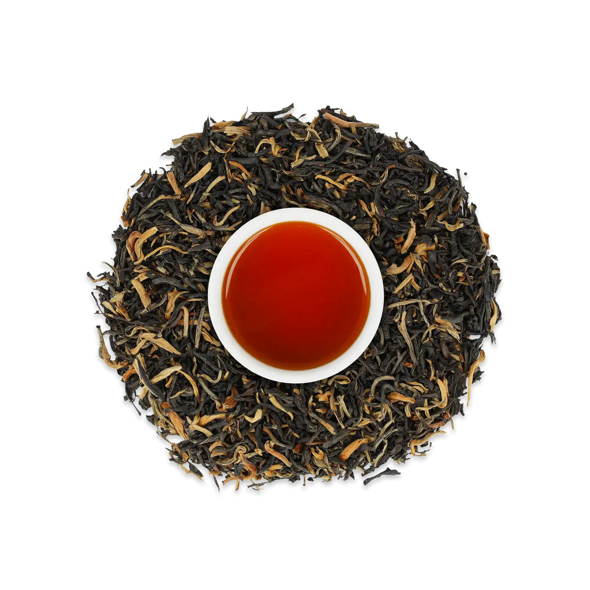 Nahaufnahme einer weißen Tasse mit Schwarzem Tee, umgeben von losen Schwarzteeblättern auf weißem Hintergrund.