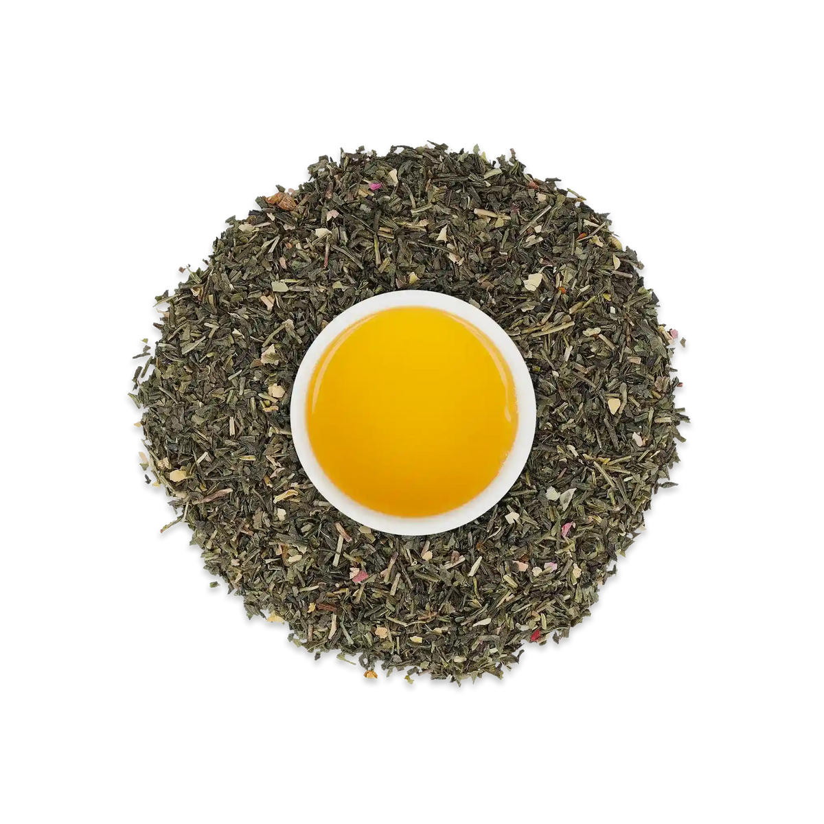 Weiße Keramiktasse mit leuchtend gelbem Tee, umgeben von getrockneten grünen Teeblättern.