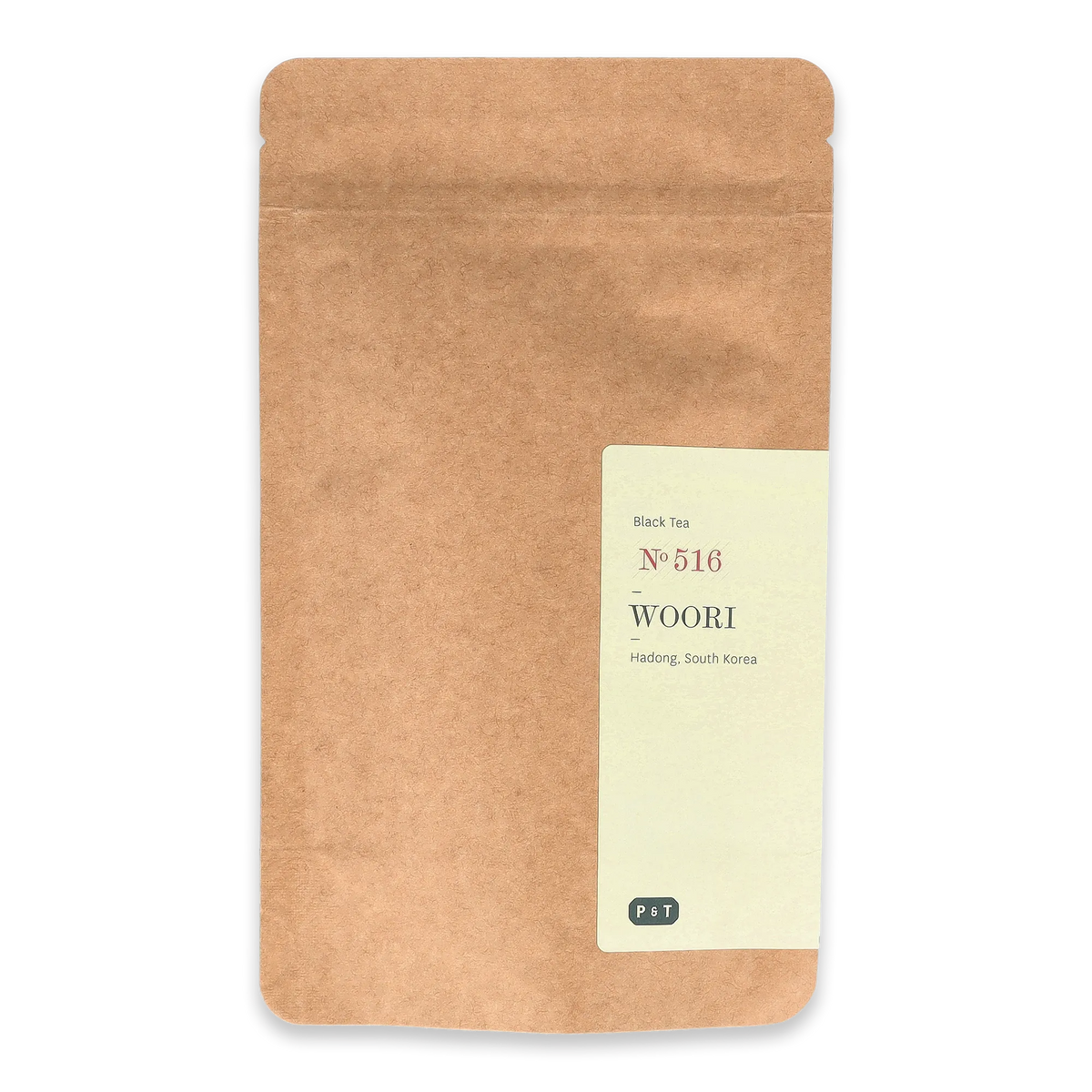 Naturbraune, wiederverschließbare Verpackung mit cremefarbenem Etikett für WOORI Black Tea No. 516 aus Hadong, Südkorea.