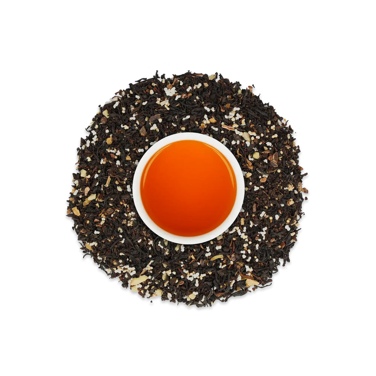Weiße Tasse mit orangefarbenem Tee, umgeben von losem Schwarztee mit weißen und hellbraunen Granulen.