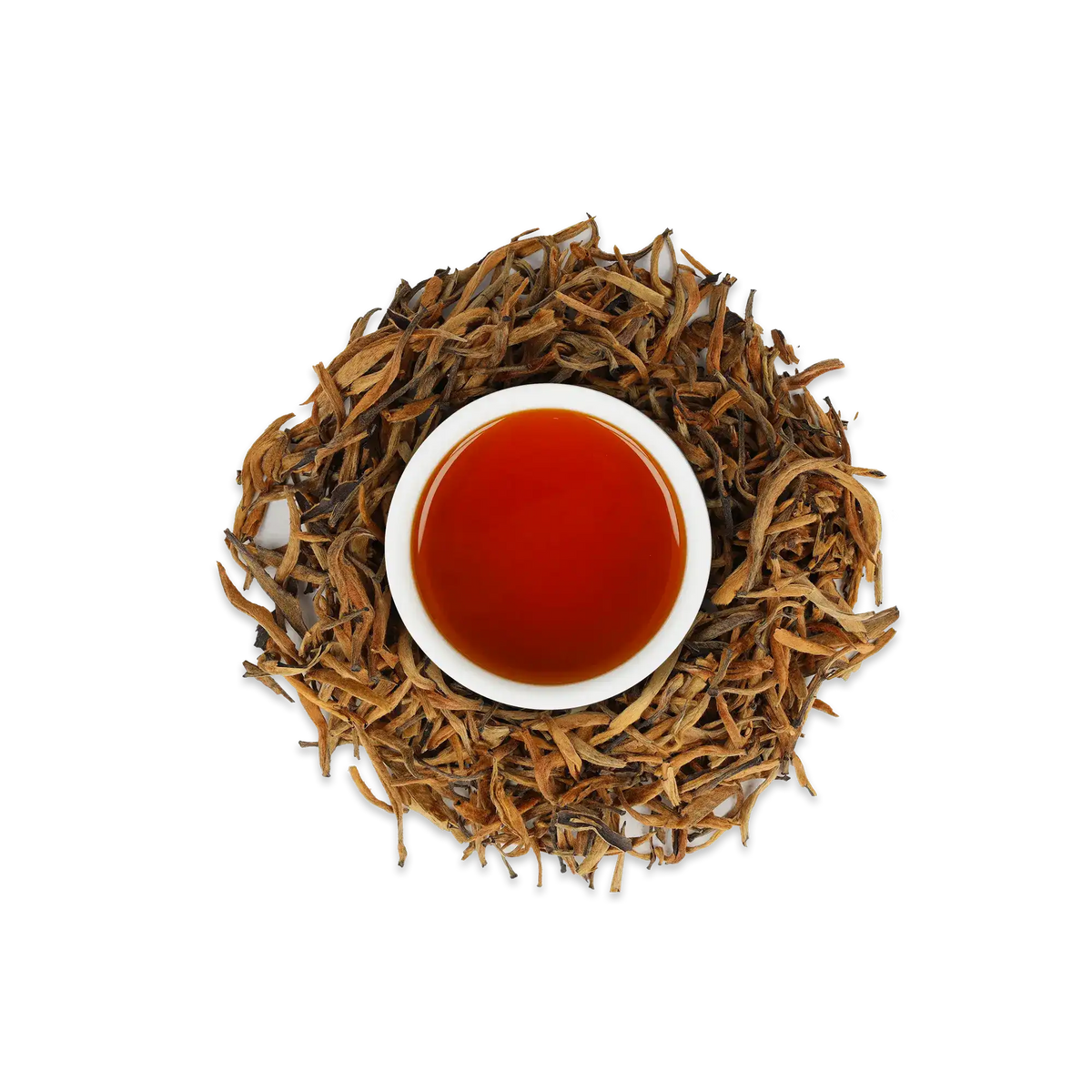 Weiße Keramiktasse mit dunklem bernsteinfarbenem Tee, umgeben von getrockneten Teeblättern auf weißem Hintergrund.