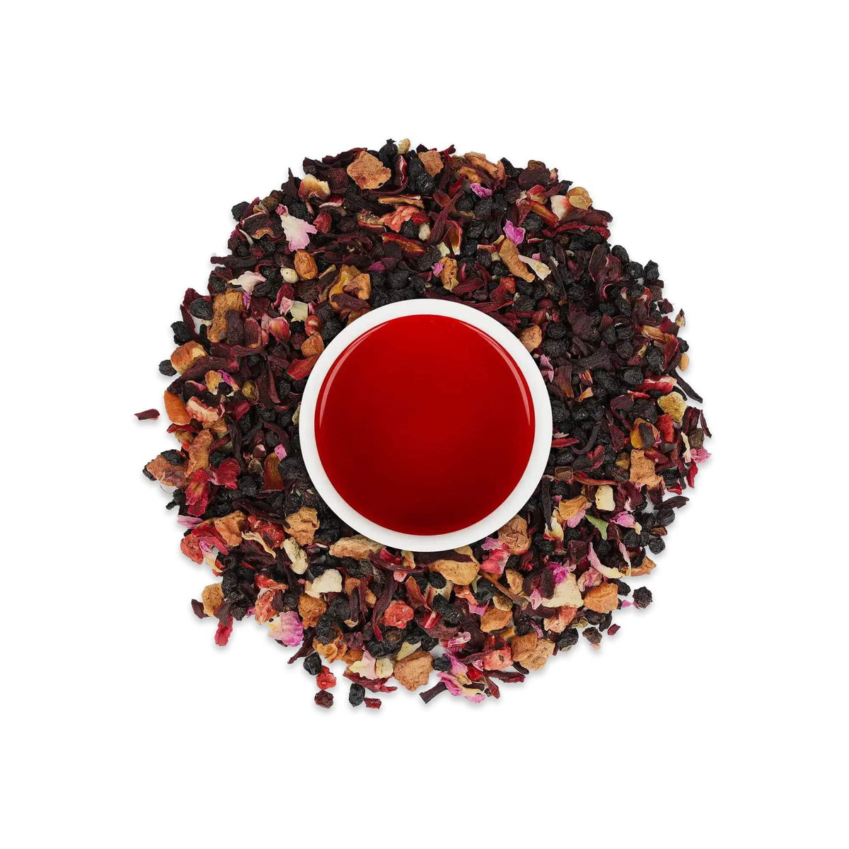 Weiße Keramiktasse mit rotem Früchtetee, umgeben von getrockneten Beeren und Blumen auf weißem Hintergrund.