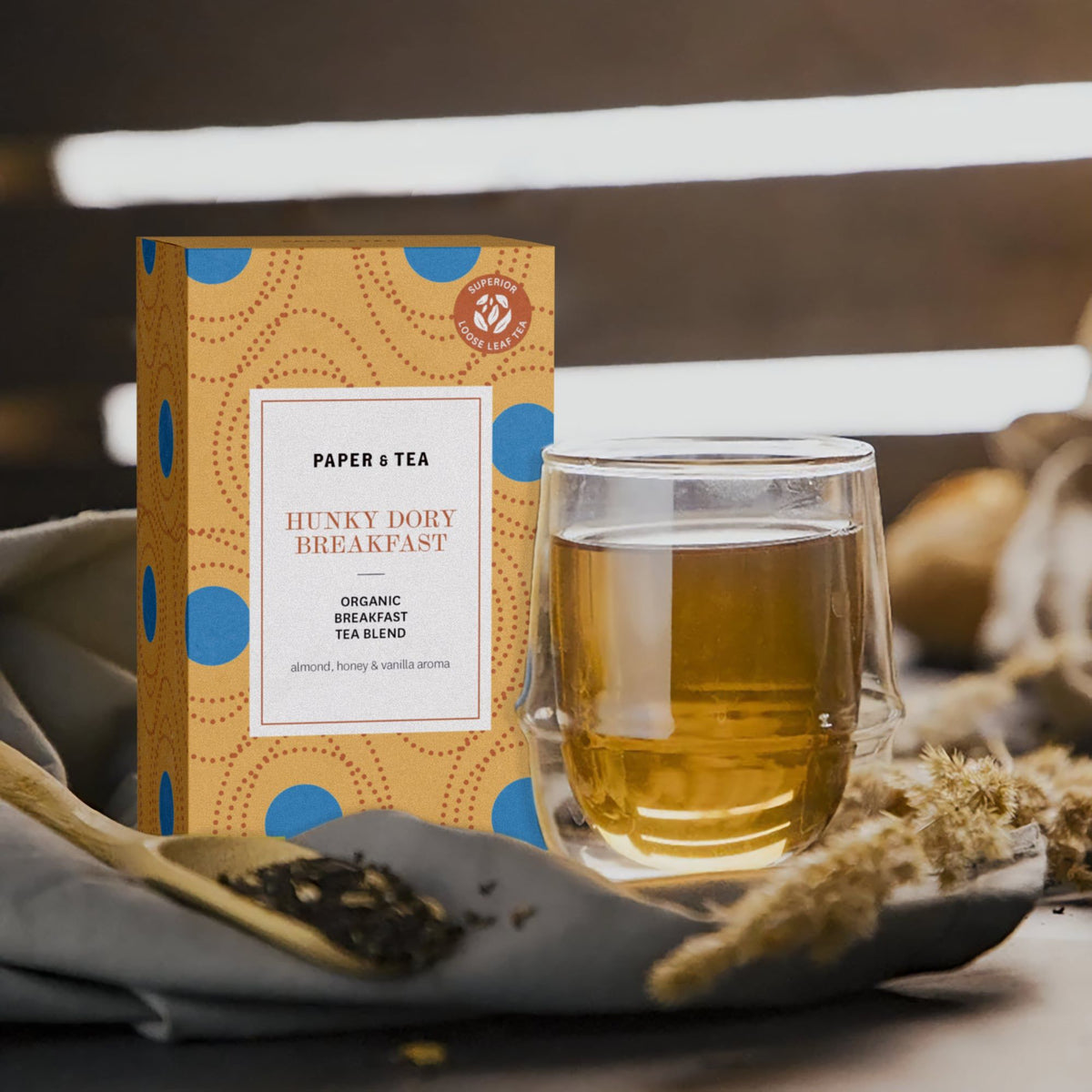 Tee-Box 'Hunky Dory Breakfast' von Paper & Tea mit Bio-Frühstückstee im Glas auf rustikalem Untergrund.