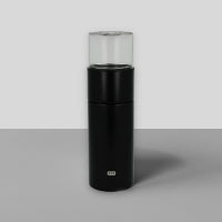 Moderner zylindrischer Behälter mit schwarzem und transparentem Design vor hellem Hintergrund