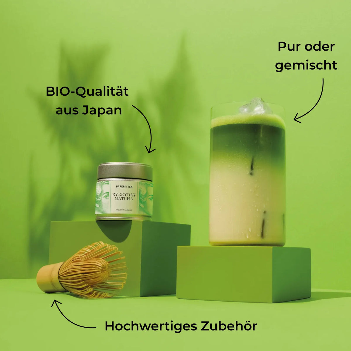 Produktdisplay mit Matcha-Dose aus Kagoshima, Matcha-Getränk mit Eis, Bambusbesen auf grünem Hintergrund