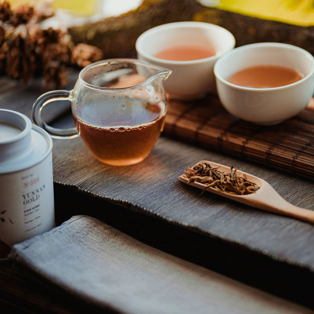 Glaskanne mit bernsteinfarbenem Dian Hong Tee, zwei Tassen, lose Teeblätter, BIO-Teedose aus Yunnan