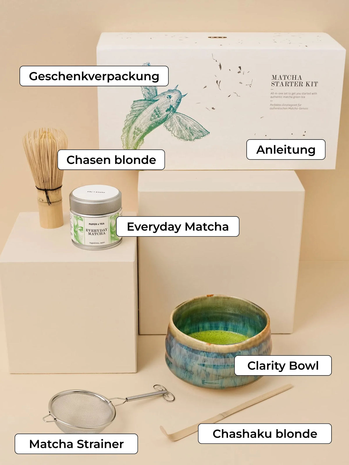 Matcha Starter Kit von PAPER & TEA mit Teedose, Bambusbesen, Keramikschale und Zubehör vor beigem Hintergrund.